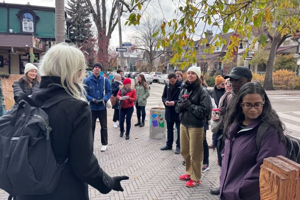 A group of people standing on a sidewalk corner