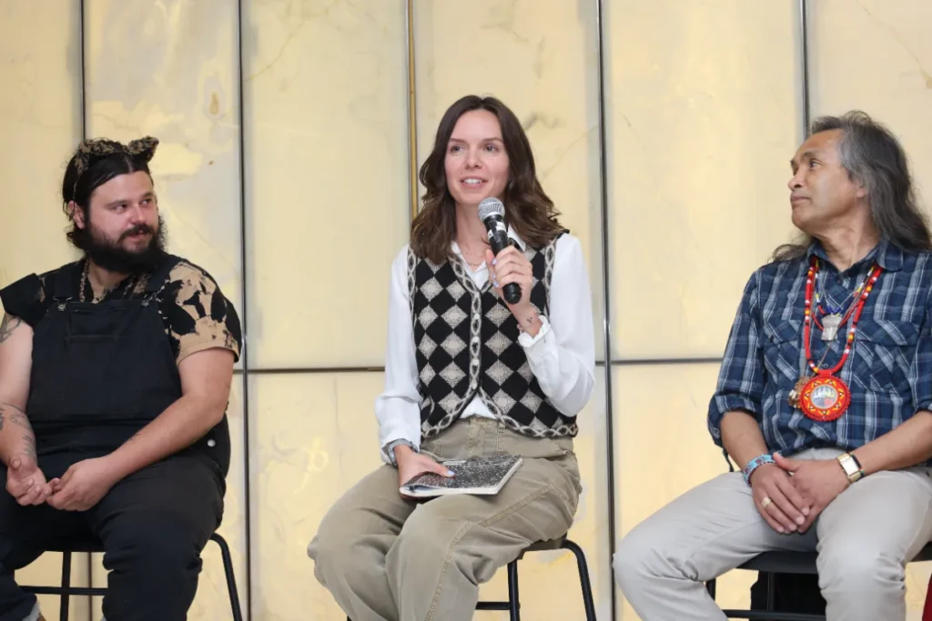 A panel speaker holding a mic