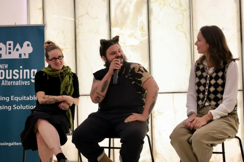 A smiling panel speaker holding a mic