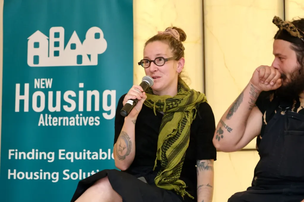 A panel speaker with glasses holding a mic