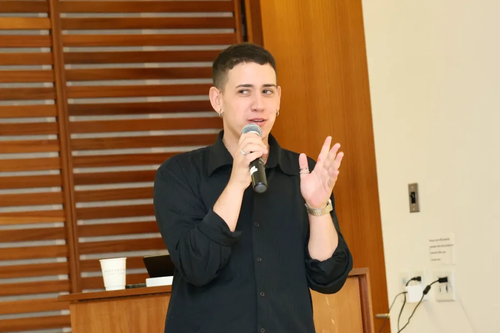 The panel host holding a mic looking sideways