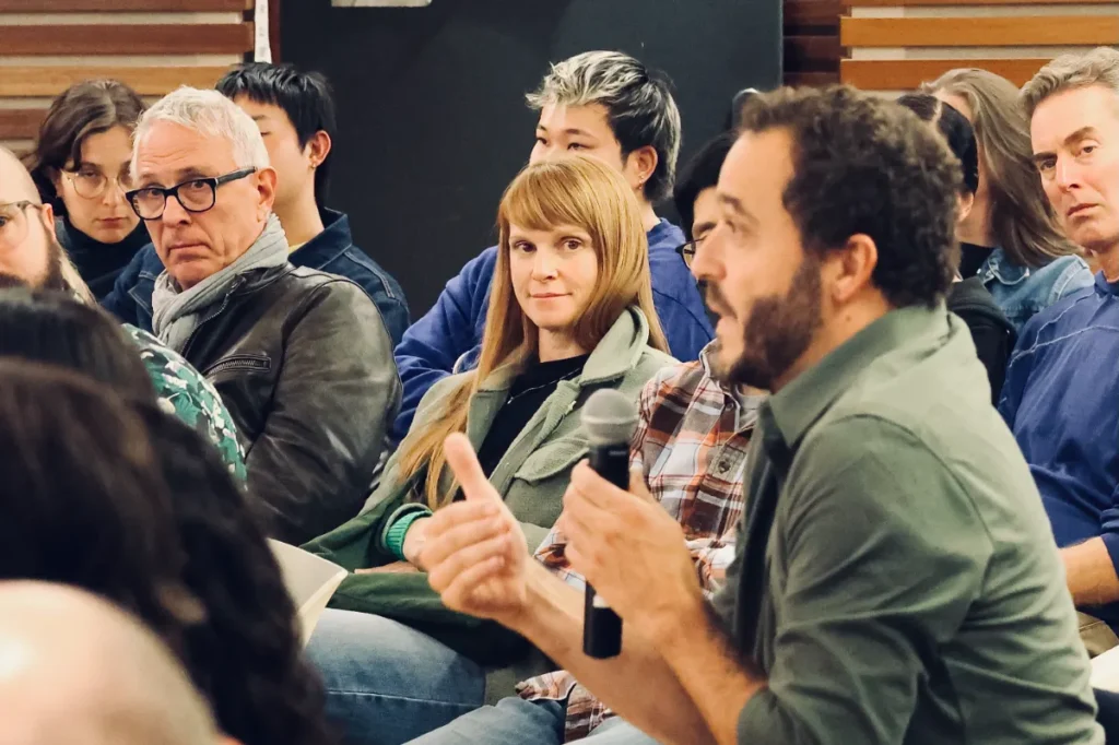 A woman looks at an audience speaking